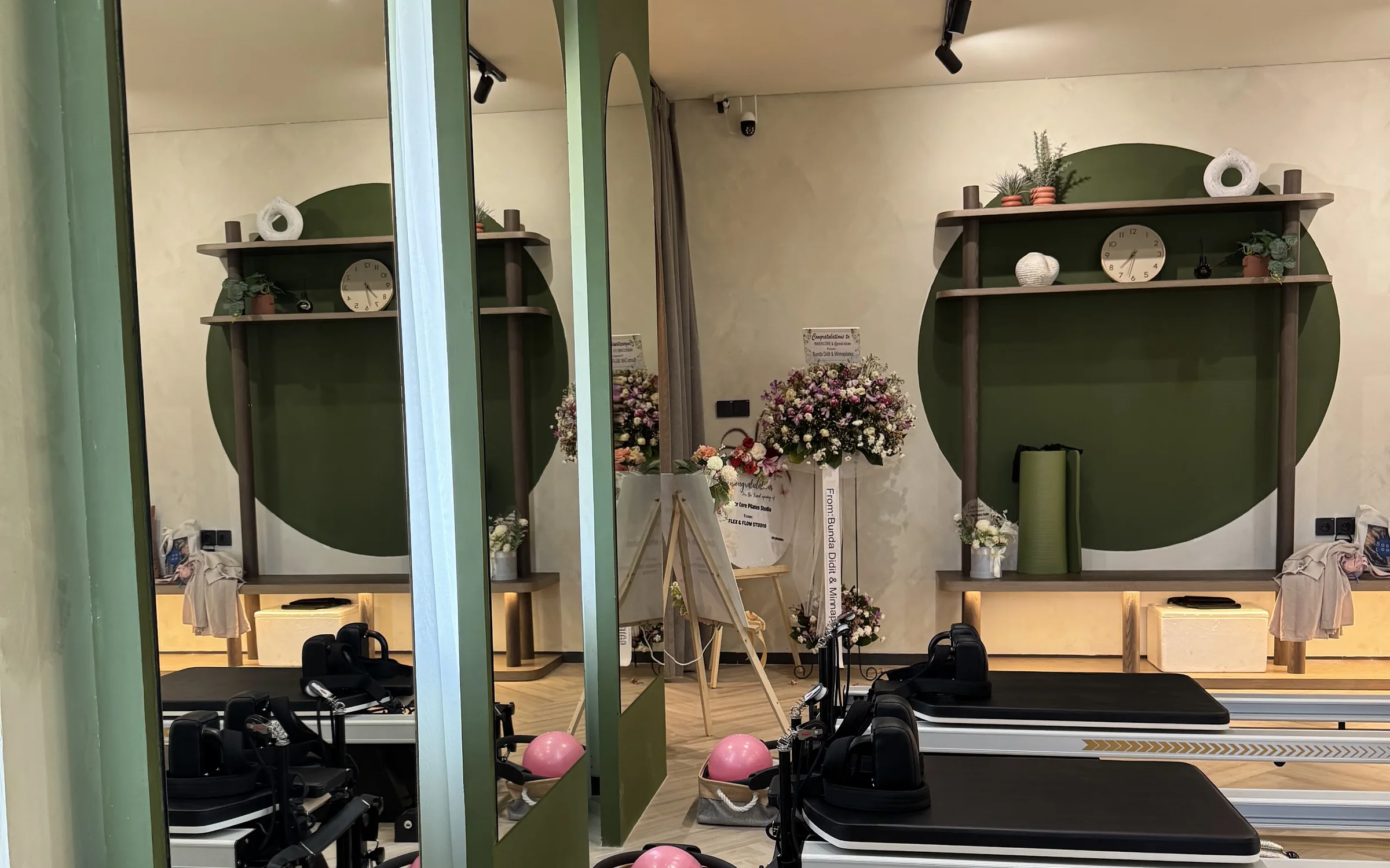 Arched mirrors, tall windows and round green shelves in the studio