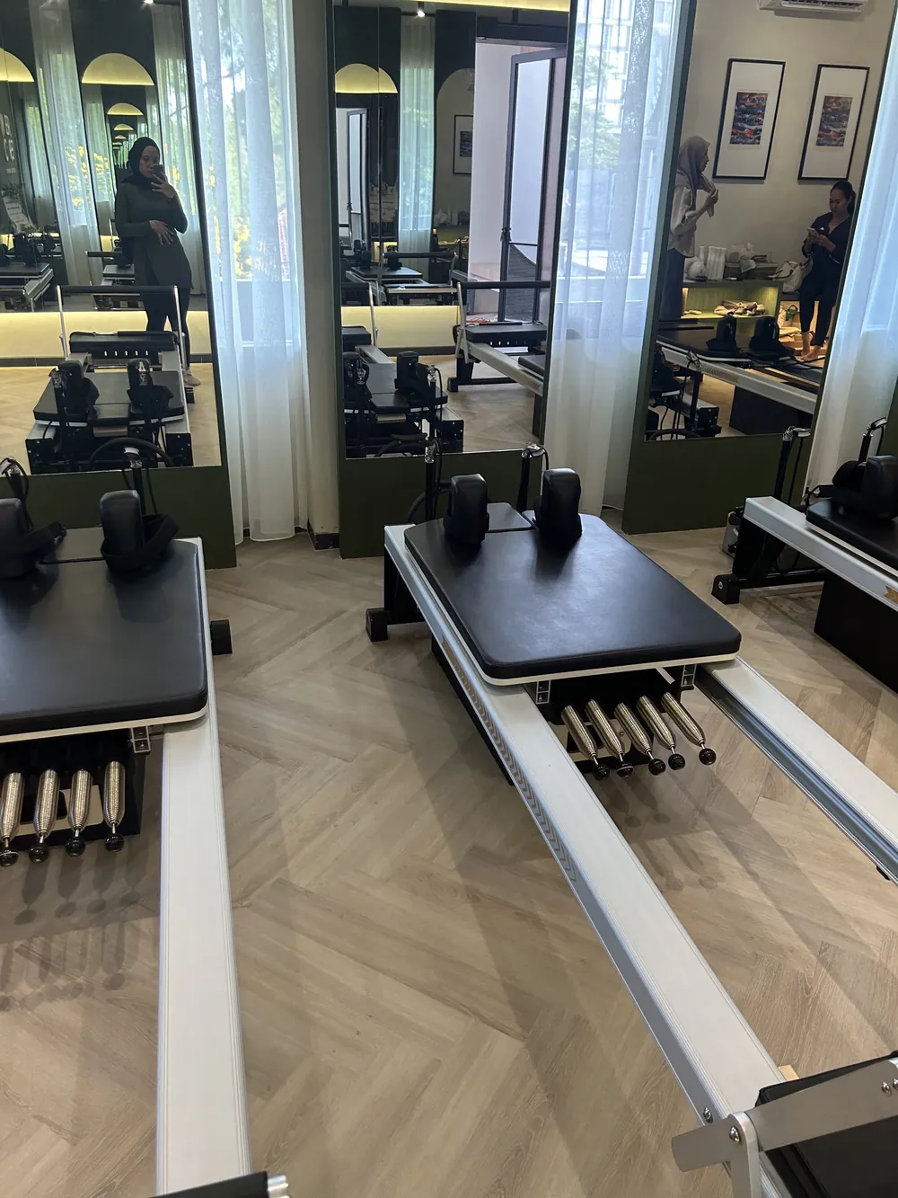 A reformer by the mirror wall, the studio reflected behind it