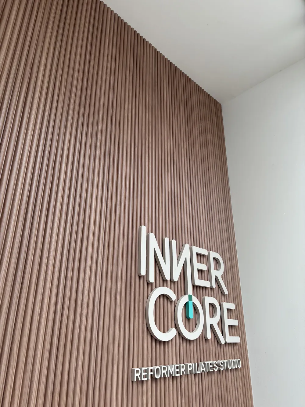 The Inner Core wordmark on oak slats at the entrance